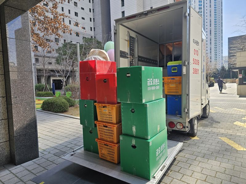 공동현관 앞 리프트에 박스를 올려 싣는 모습