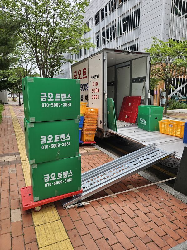 상호가 찍힌 초록 박스 3단 대차와 탑차 경사판